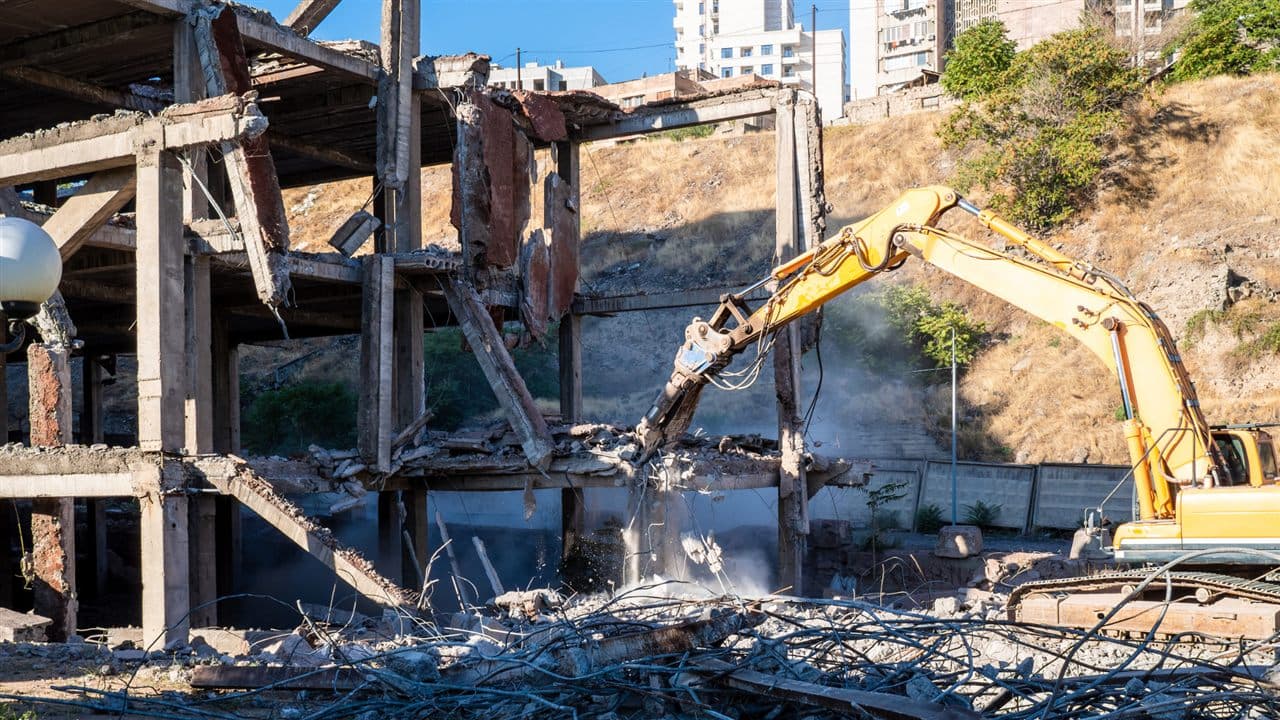 Excavator demolishing a concrete building