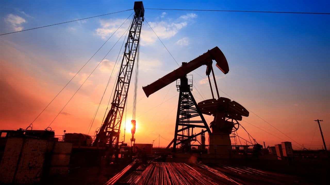 Oil pump jacks at sunset in an oil and gas field